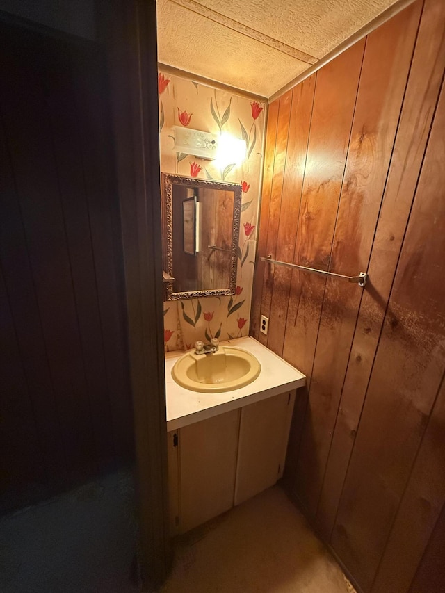 489 Lovejoy Pond Rd, Fayette, ME 04349 - bathroom featuring vanity, wood walls, and a textured ceiling