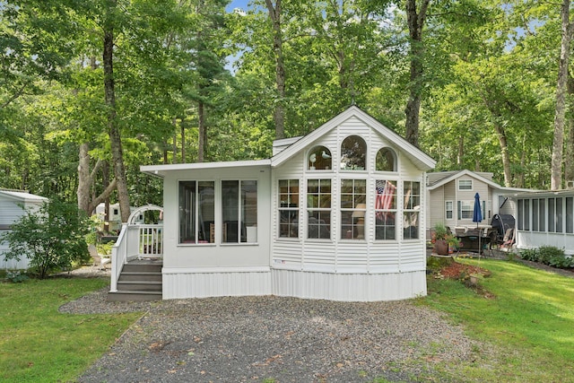 191 Tatnic Rd Unit 74, Wells, ME 04090 - back of house featuring a sunroom, a yard, and view of wooded area