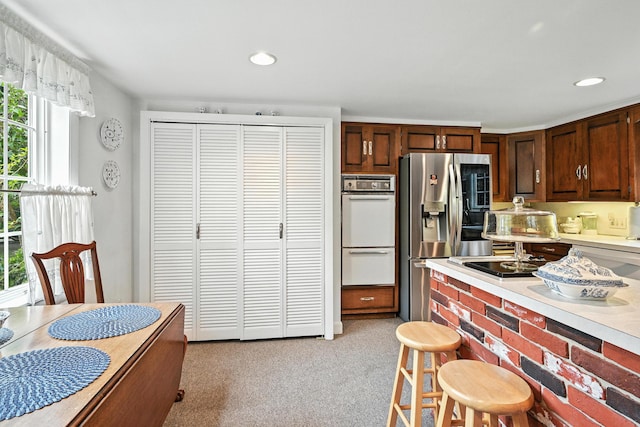 43 Green St, Augusta, ME 04330 - kitchen featuring white appliances, light countertops, a kitchen breakfast bar, light carpet, and recessed lighting