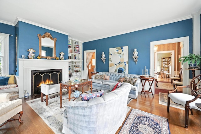 43 Green St, Augusta, ME 04330 - living area featuring wood finished floors, ornamental molding, a fireplace with flush hearth, and built in features