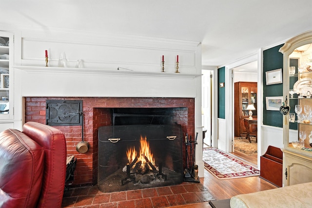 43 Green St, Augusta, ME 04330 - detailed view of a brick fireplace, a wainscoted wall, and wood finished floors