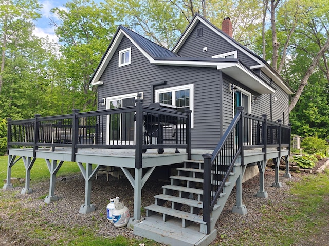 48 Sebasticook Ave, Newport, ME 04953 - rear view of property featuring a chimney, a deck, view of scattered trees, and stairs