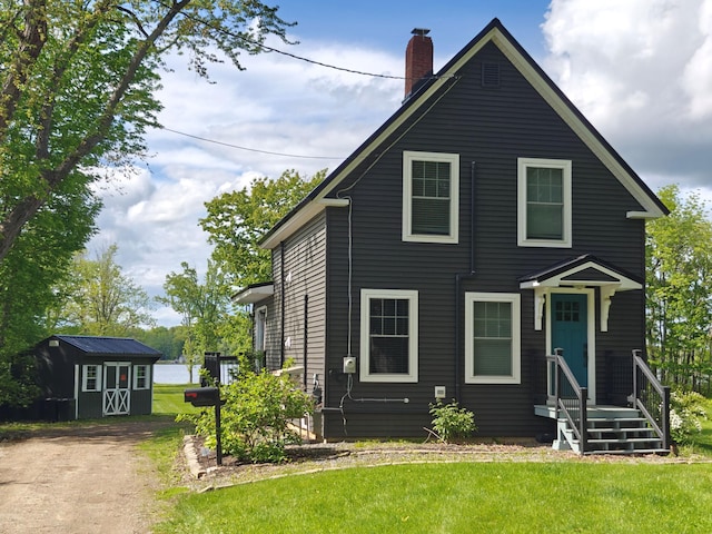 48 Sebasticook Ave, Newport, ME 04953 - view of front of home with a storage unit, a chimney, and a front lawn