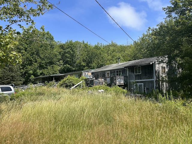 957 Tunk Lake Rd, Sullivan, ME 04664 - view of front of home with a view of trees and a wooden deck