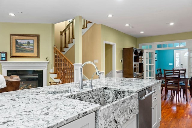 38 Harvest Hill Ln Unit 38, Auburn, ME 04210 - kitchen featuring light stone counters, recessed lighting, white cabinets, dark wood-style floors, and a glass covered fireplace