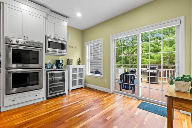 38 Harvest Hill Ln Unit 38, Auburn, ME 04210 - kitchen with wine cooler, stainless steel appliances, light wood-style flooring, white cabinets, and recessed lighting