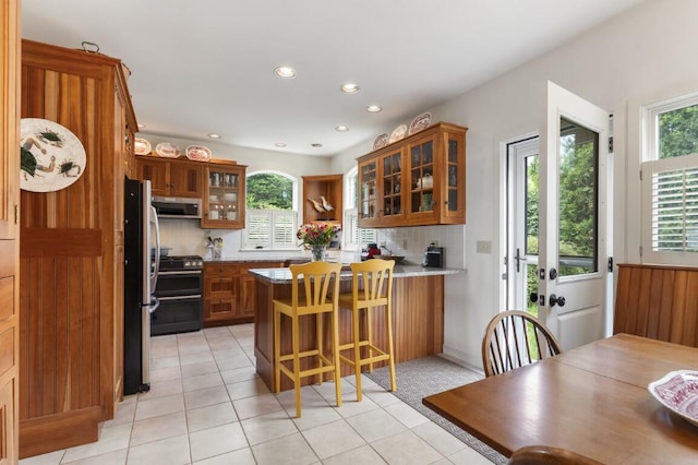 1 Grimes Ave, Boothbay, ME 04544 - kitchen with a peninsula, brown cabinetry, range hood, freestanding refrigerator, and double oven range