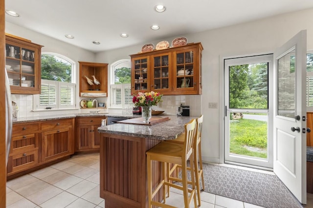 1 Grimes Ave, Boothbay, ME 04544 - kitchen featuring brown cabinets, a peninsula, backsplash, light stone countertops, and recessed lighting