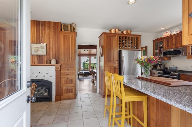 1 Grimes Ave, Boothbay, ME 04544 - kitchen featuring appliances with stainless steel finishes, glass insert cabinets, light tile patterned flooring, stone countertops, and decorative backsplash