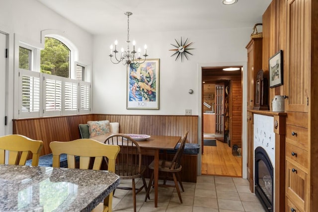1 Grimes Ave, Boothbay, ME 04544 - dining room with wainscoting, a chandelier, washer / clothes dryer, light tile patterned floors, and wooden walls
