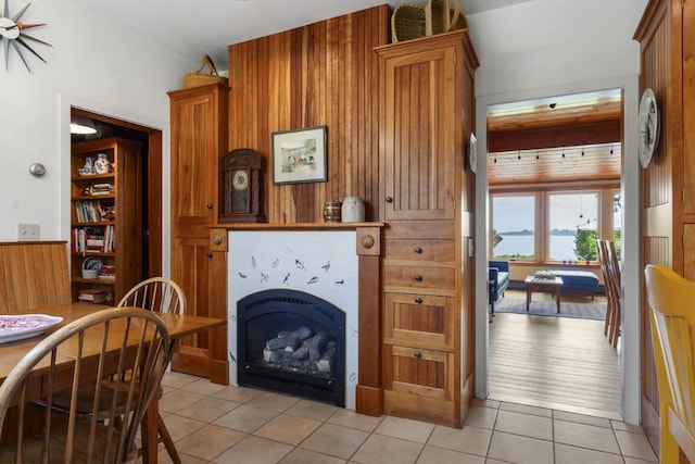 1 Grimes Ave, Boothbay, ME 04544 - living area featuring a tile fireplace, light tile patterned floors, and wood walls