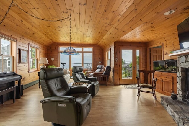 1 Grimes Ave, Boothbay, ME 04544 - living area with vaulted ceiling, wood walls, wooden ceiling, plenty of natural light, and a stone fireplace