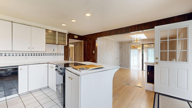 307 Russell St, Lewiston, ME 04240 - kitchen with light countertops, black appliances, a peninsula, white cabinets, and wooden walls