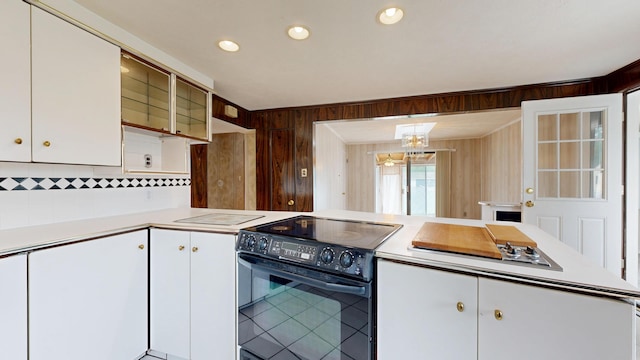 307 Russell St, Lewiston, ME 04240 - kitchen with black appliances, light countertops, backsplash, white cabinets, and wood walls