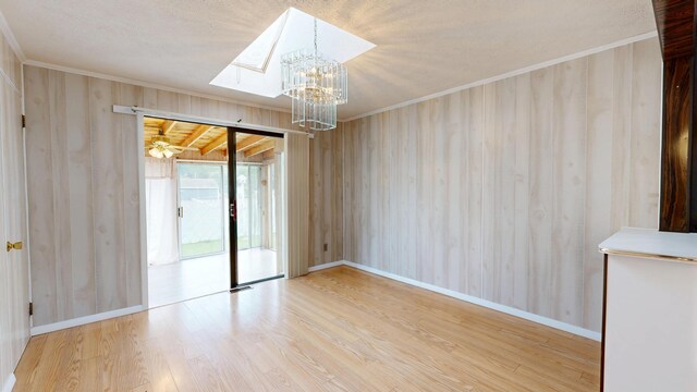 307 Russell St, Lewiston, ME 04240 - empty room with a chandelier, crown molding, wood finished floors, and wood walls