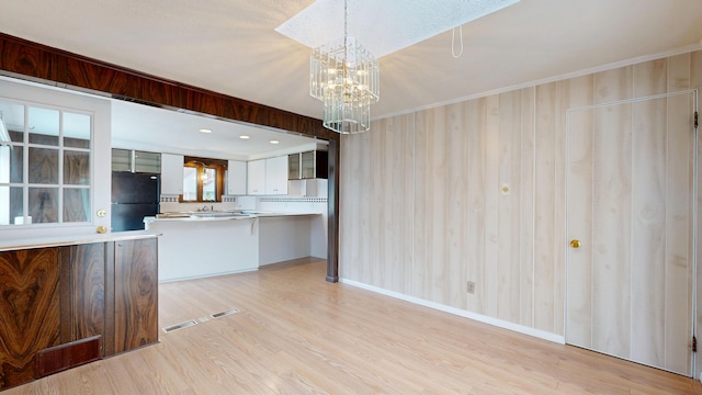 307 Russell St, Lewiston, ME 04240 - kitchen featuring freestanding refrigerator, light wood-style floors, light countertops, a chandelier, and a peninsula