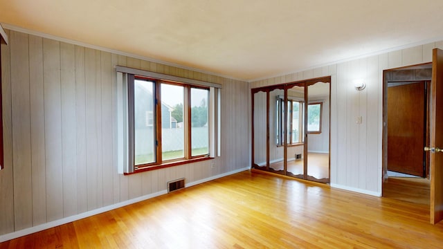 307 Russell St, Lewiston, ME 04240 - unfurnished room with light wood-type flooring, ornamental molding, and wood walls