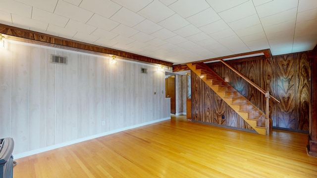 307 Russell St, Lewiston, ME 04240 - unfurnished living room featuring wooden walls, wood finished floors, and stairs