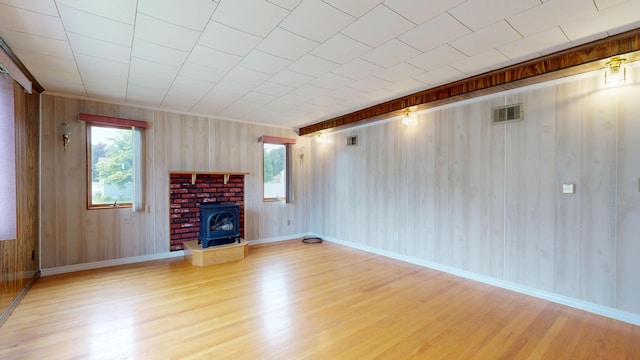 307 Russell St, Lewiston, ME 04240 - unfurnished living room with wood finished floors, wooden walls, and a fireplace