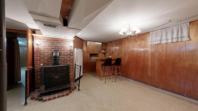 307 Russell St, Lewiston, ME 04240 - indoor dry bar with tile patterned floors, wooden walls, a wood stove, and a chandelier