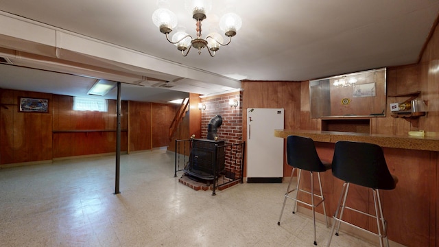 307 Russell St, Lewiston, ME 04240 - kitchen with wooden walls, a wood stove, freestanding refrigerator, tile patterned floors, and a chandelier