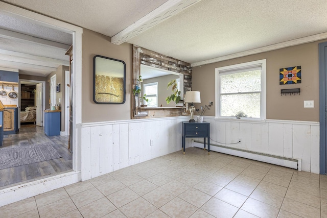 14 Bailey Ln, Brunswick, ME 04011 - empty room with a wainscoted wall, a textured ceiling, a baseboard heating unit, tile patterned floors, and wooden walls