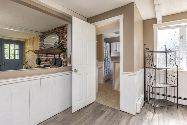 14 Bailey Ln, Brunswick, ME 04011 - hallway with a wainscoted wall, light wood-style flooring, and a textured ceiling