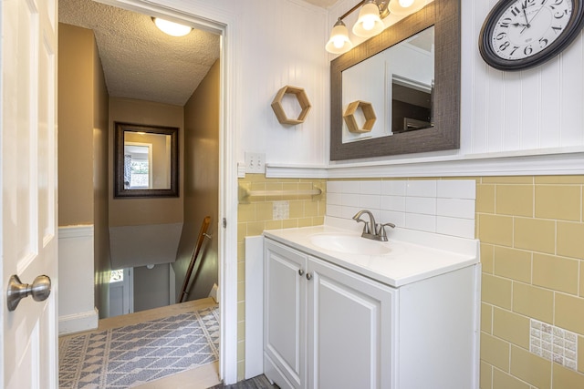 14 Bailey Ln, Brunswick, ME 04011 - bathroom featuring vanity, tile walls, a wainscoted wall, and a textured ceiling