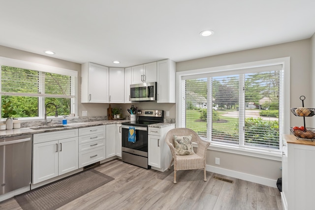 20 Wonderbrook Dr Unit 20, Kennebunk, ME 04043 - kitchen with appliances with stainless steel finishes, white cabinetry, light wood-type flooring, light stone counters, and recessed lighting