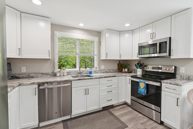 20 Wonderbrook Dr Unit 20, Kennebunk, ME 04043 - kitchen featuring appliances with stainless steel finishes, white cabinets, light wood finished floors, recessed lighting, and light stone countertops