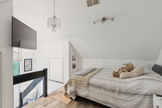 20 Wonderbrook Dr Unit 20, Kennebunk, ME 04043 - bedroom with wood finished floors, vaulted ceiling, and a chandelier
