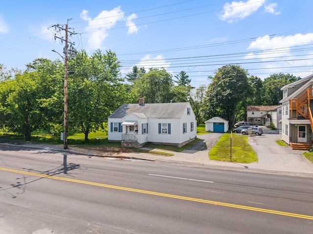 395 Alfred St, Biddeford, ME 04005 - bungalow-style home with a chimney, a detached garage, and view of wooded area