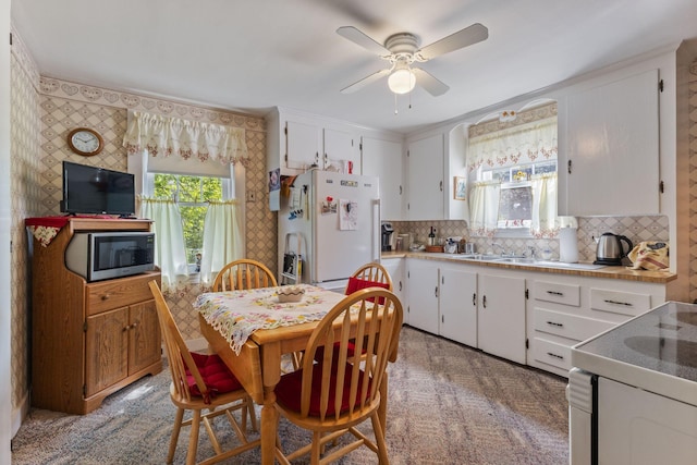 395 Alfred St, Biddeford, ME 04005 - kitchen with white appliances, ceiling fan, white cabinetry, and tasteful backsplash