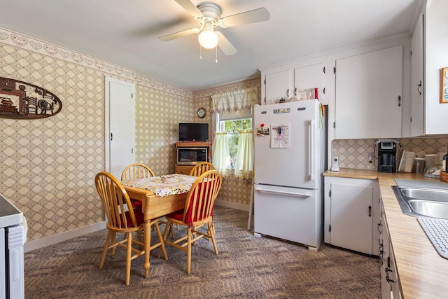 395 Alfred St, Biddeford, ME 04005 - kitchen with freestanding refrigerator, white cabinetry, a ceiling fan, stainless steel microwave, and wallpapered walls