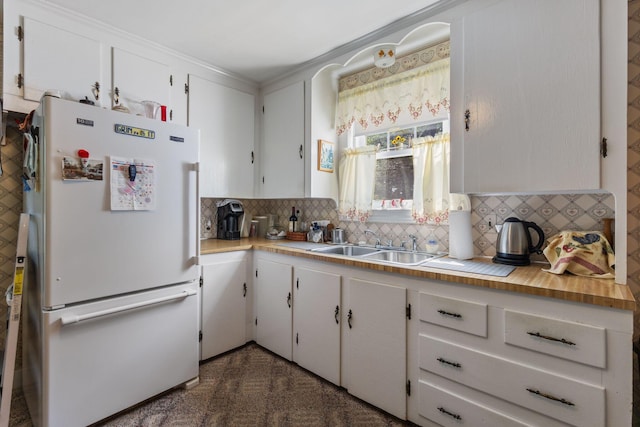 395 Alfred St, Biddeford, ME 04005 - kitchen with freestanding refrigerator, tasteful backsplash, light countertops, white cabinetry, and crown molding