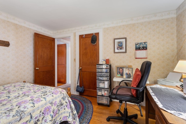 395 Alfred St, Biddeford, ME 04005 - bedroom featuring wood finished floors, wallpapered walls, and an office area