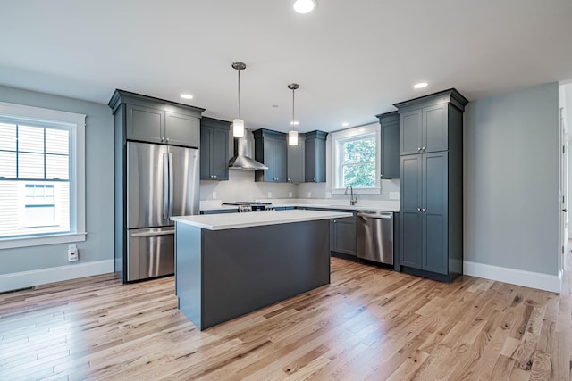 189 Falcon Crest Dr Unit 31, Gorham, ME 04038 - kitchen with stainless steel appliances, light countertops, light wood finished floors, wall chimney exhaust hood, and a center island