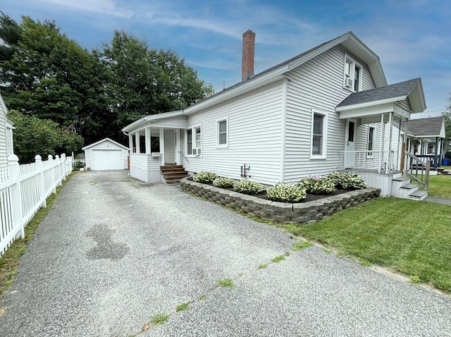 6 Shirley Ave, Lewiston, ME 04240 - view of property exterior featuring covered porch, an outdoor structure, a garage, and asphalt driveway