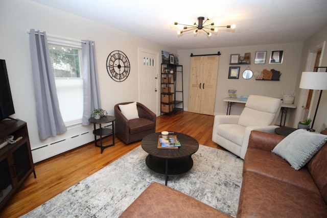 6 Shirley Ave, Lewiston, ME 04240 - living area with baseboard heating, a barn door, wood finished floors, and a chandelier