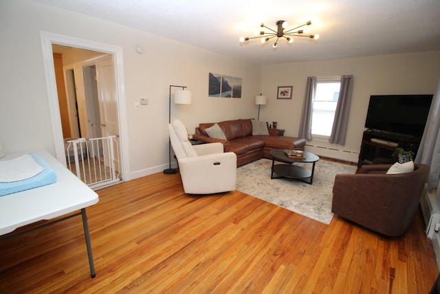 6 Shirley Ave, Lewiston, ME 04240 - living area with a baseboard heating unit, a chandelier, and light wood-type flooring