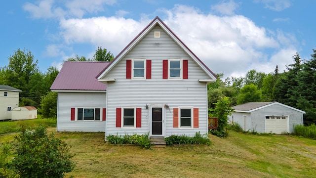 2300 Hudson Rd, Hudson, ME 04449 - back of house featuring an outbuilding, a yard, a detached garage, and a metal roof