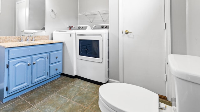 2300 Hudson Rd, Hudson, ME 04449 - bathroom with washer and dryer, vanity, and stone finish flooring