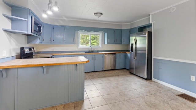 2300 Hudson Rd, Hudson, ME 04449 - kitchen featuring stainless steel appliances, a peninsula, blue cabinetry, crown molding, and a kitchen bar