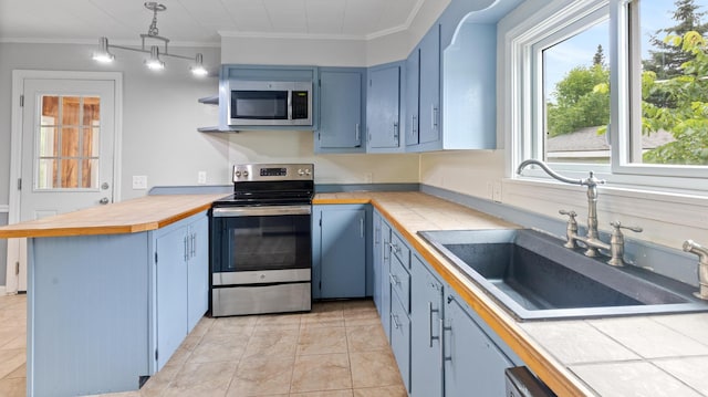 2300 Hudson Rd, Hudson, ME 04449 - kitchen featuring stainless steel appliances, a peninsula, blue cabinetry, crown molding, and tile counters