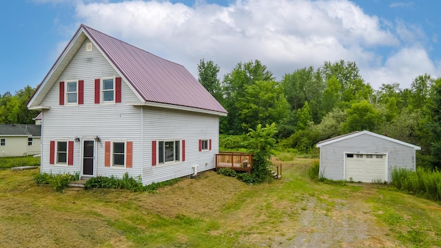 2300 Hudson Rd, Hudson, ME 04449 - back of house with a detached garage, an outbuilding, driveway, a metal roof, and a yard