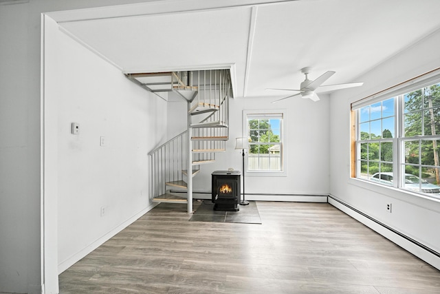 3 Gedney St, Augusta, ME 04330 - unfurnished living room featuring plenty of natural light, a wood stove, stairs, and ceiling fan