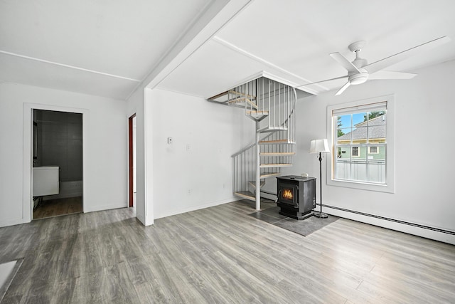 3 Gedney St, Augusta, ME 04330 - unfurnished living room featuring a wood stove, stairs, wood finished floors, and a ceiling fan