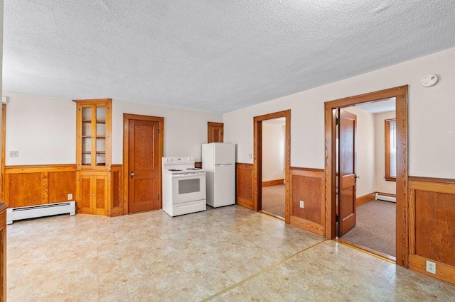 99 Hill St, Biddeford, ME 04005 - kitchen with a wainscoted wall, a textured ceiling, wood walls, white appliances, and light floors
