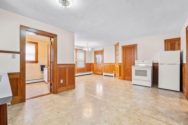 99 Hill St, Biddeford, ME 04005 - kitchen featuring a wainscoted wall, white appliances, a chandelier, a textured ceiling, and baseboard heating