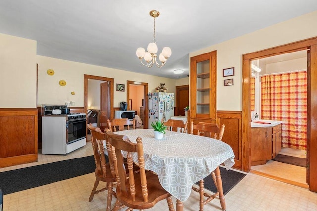 99 Hill St, Biddeford, ME 04005 - dining area with light flooring, a wainscoted wall, and a chandelier